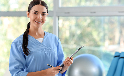 Physical therapy aide holding clipboard